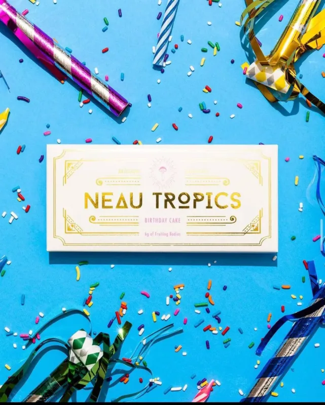 Colorful Neau Tropics THC-infused gummies in a clear container with tropical-themed packaging.