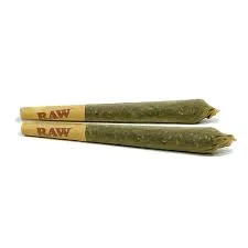 An assortment of cannabis pre-rolls neatly arranged on a wooden tray, with a few glass tubes and containers in the background.